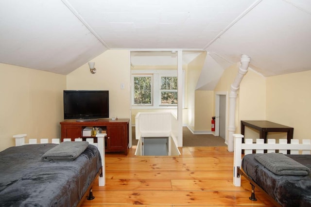 bedroom with light wood-type flooring and lofted ceiling