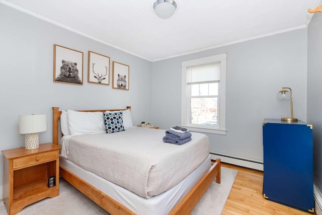 bedroom featuring hardwood / wood-style floors, crown molding, and a baseboard radiator