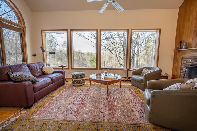 living room with ceiling fan and a brick fireplace