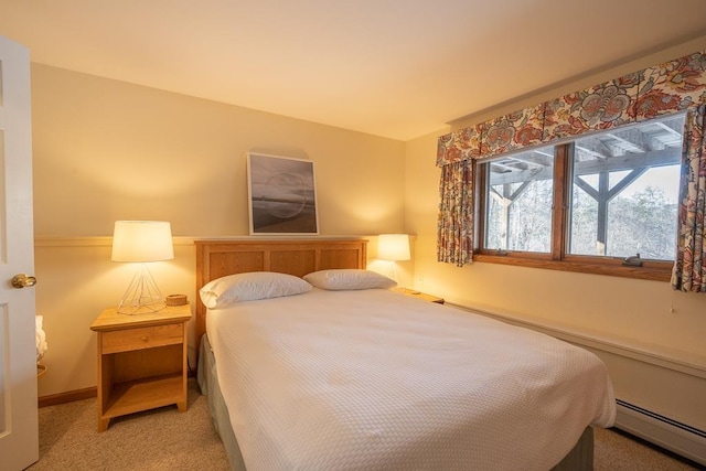 bedroom with carpet and a baseboard heating unit