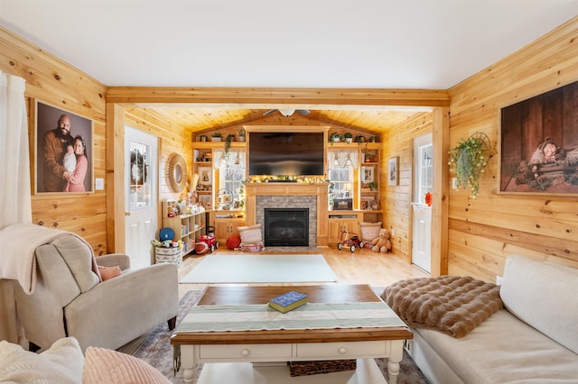 living room with vaulted ceiling with beams, wood walls, a fireplace, and hardwood / wood-style flooring