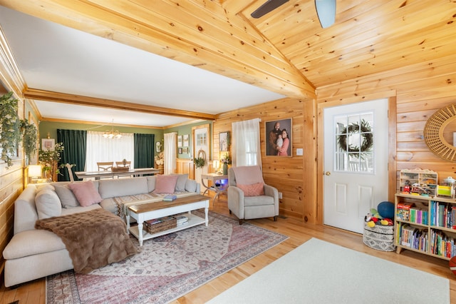 living room featuring lofted ceiling, light hardwood / wood-style floors, and ceiling fan with notable chandelier