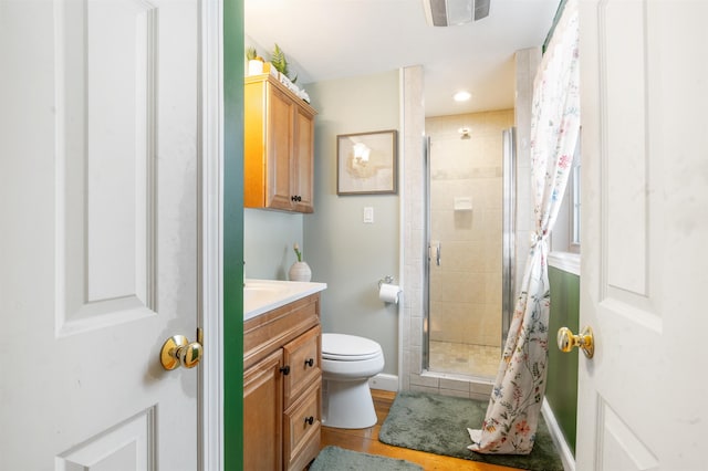 bathroom featuring tile patterned floors, toilet, vanity, and walk in shower