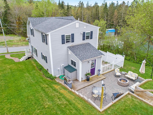 rear view of house with a lawn, a patio, and a fire pit