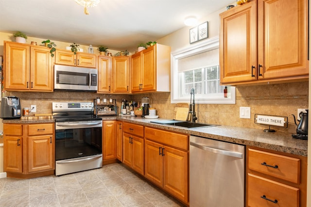 kitchen featuring backsplash, sink, and appliances with stainless steel finishes