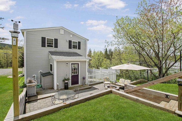 back of property featuring a lawn, a patio, and an outdoor living space with a fire pit