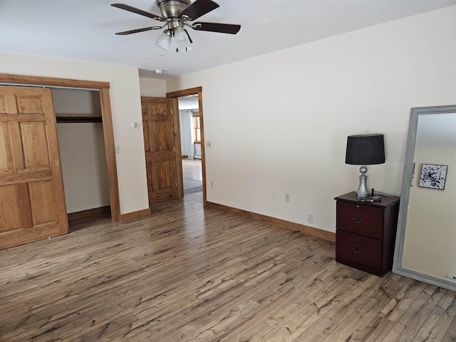 unfurnished bedroom with a closet, light hardwood / wood-style flooring, and ceiling fan