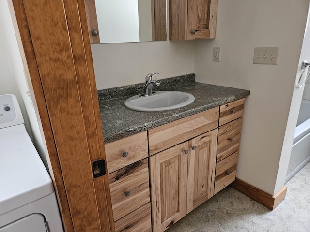 bathroom featuring vanity and washer / dryer