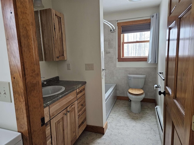 bathroom with toilet, vanity, tile walls, and a baseboard heating unit