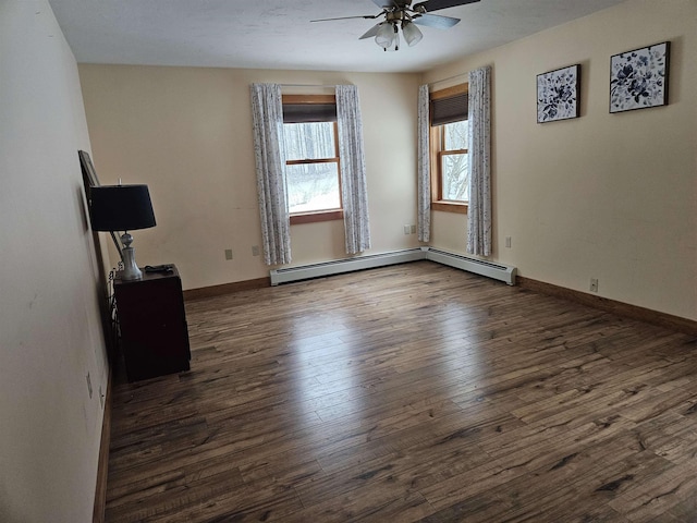 spare room with baseboard heating, ceiling fan, and dark hardwood / wood-style floors