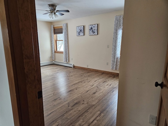 spare room with ceiling fan, light hardwood / wood-style flooring, and a baseboard heating unit