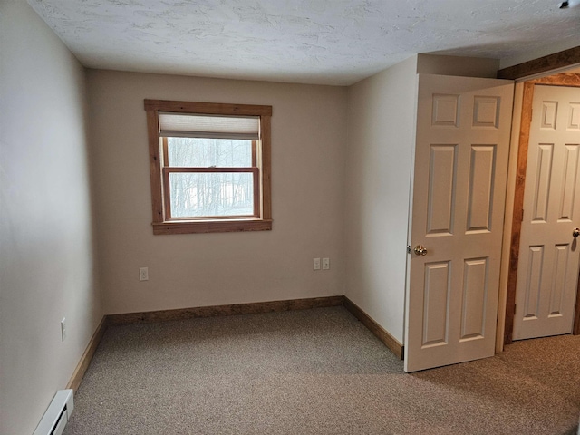 spare room with carpet, a textured ceiling, and baseboard heating