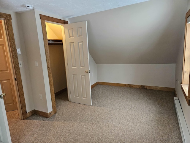 additional living space with carpet floors, vaulted ceiling, and baseboard heating