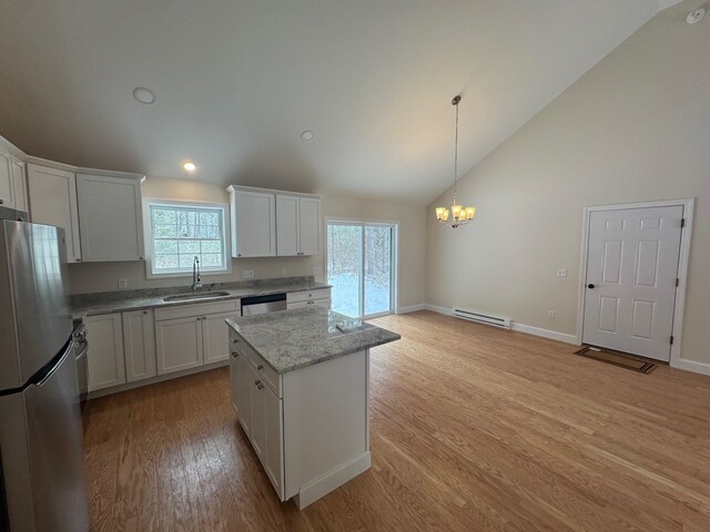 kitchen featuring a baseboard heating unit, sink, a kitchen island, white cabinetry, and stainless steel appliances