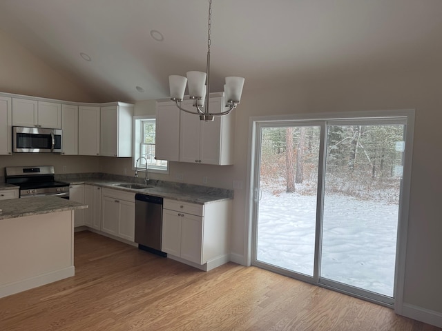 kitchen with sink, stainless steel appliances, a notable chandelier, decorative light fixtures, and white cabinets