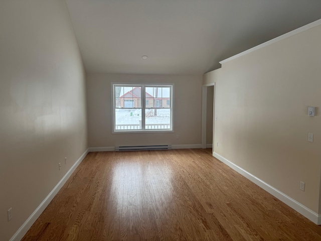 unfurnished room with wood-type flooring and a baseboard heating unit