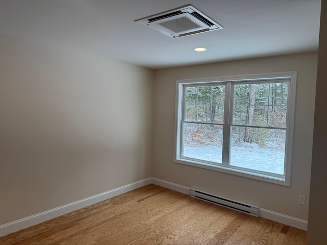 empty room featuring light hardwood / wood-style flooring and a baseboard radiator