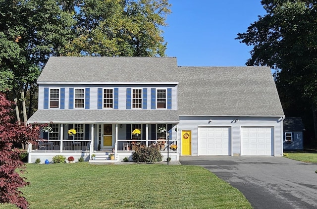 view of front of house with covered porch, a front lawn, and a garage