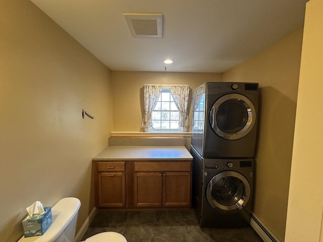 clothes washing area featuring a baseboard radiator and stacked washer and dryer