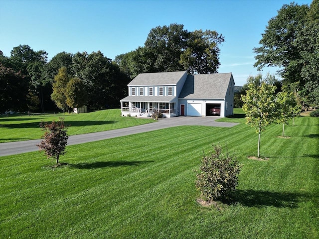 colonial home featuring covered porch, a front lawn, an attached garage, and aphalt driveway