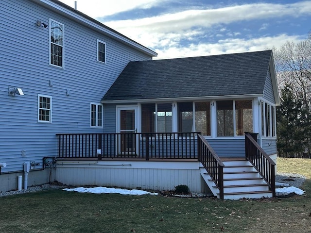 rear view of house with a yard and a sunroom