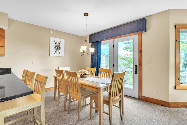 dining space featuring light colored carpet, an inviting chandelier, and a wealth of natural light