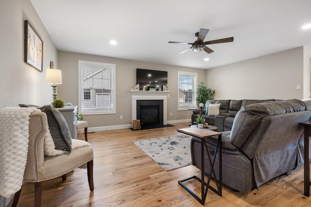 living room featuring light wood-type flooring and ceiling fan