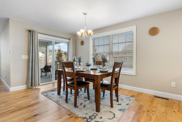 dining room featuring light hardwood / wood-style flooring and an inviting chandelier