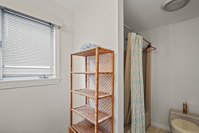 bathroom with toilet and shower / bathtub combination with curtain