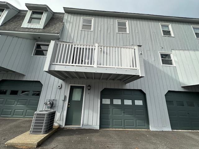 view of front of house featuring a garage, a balcony, and central AC