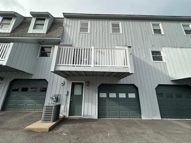 view of front of home with central air condition unit and a balcony