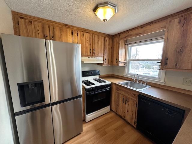 kitchen with sink, black dishwasher, stainless steel fridge with ice dispenser, light wood-type flooring, and white gas range oven