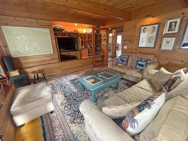 living room featuring beam ceiling, wooden walls, and wooden ceiling