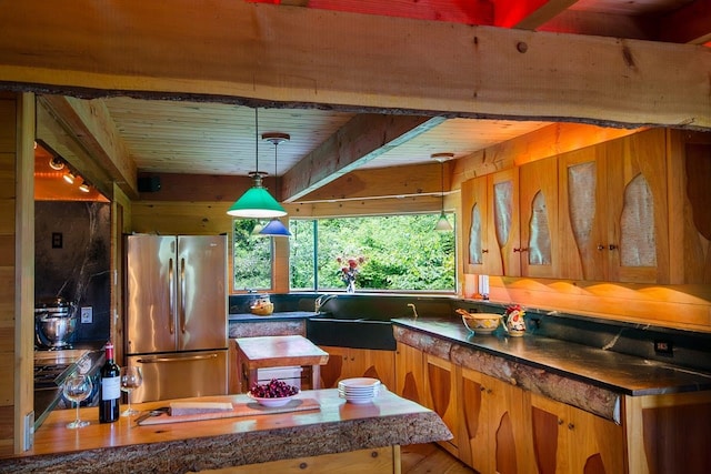 kitchen with pendant lighting, stainless steel refrigerator, wooden ceiling, and sink