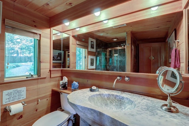 bathroom featuring toilet, wooden ceiling, sink, and wooden walls