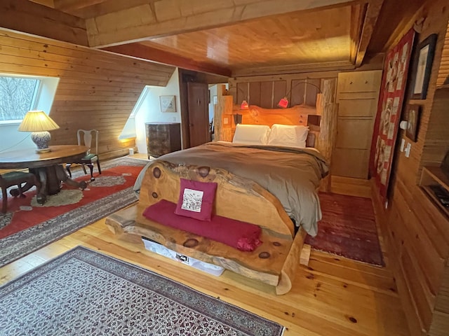 bedroom with hardwood / wood-style floors and wooden walls