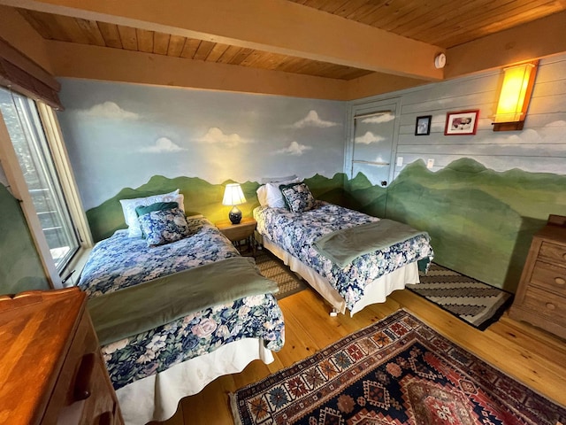 bedroom featuring beamed ceiling, wood-type flooring, and wood walls