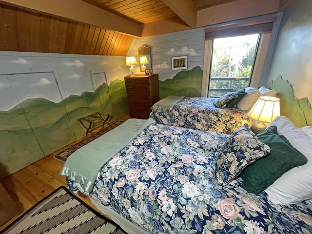 bedroom with lofted ceiling with beams, wood walls, hardwood / wood-style floors, and wooden ceiling