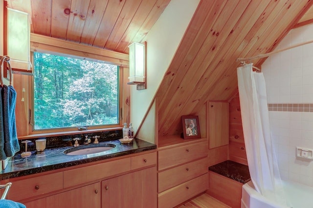 bathroom with vanity, wood walls, and lofted ceiling