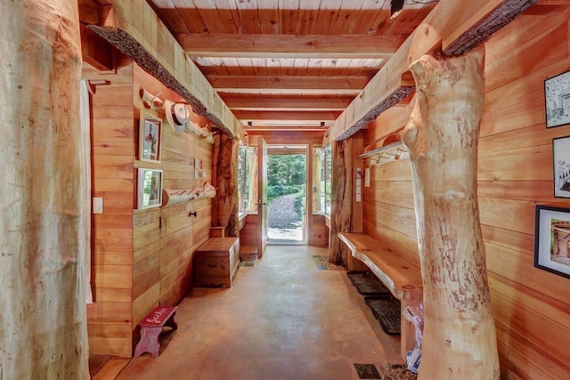 interior space with beamed ceiling, wooden walls, and wood ceiling