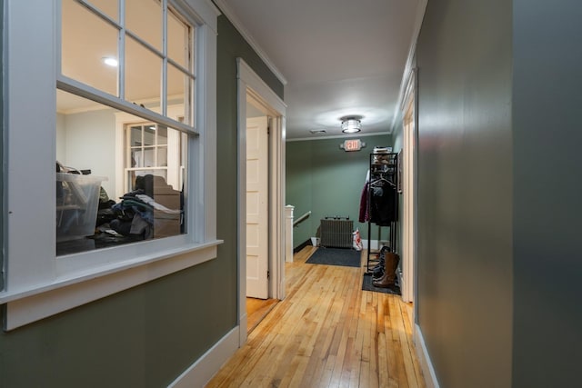 hallway featuring light wood-type flooring and ornamental molding