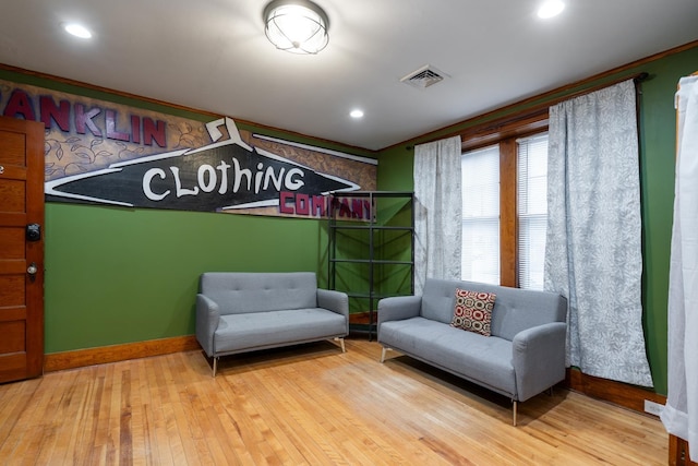 living area featuring ornamental molding and hardwood / wood-style flooring