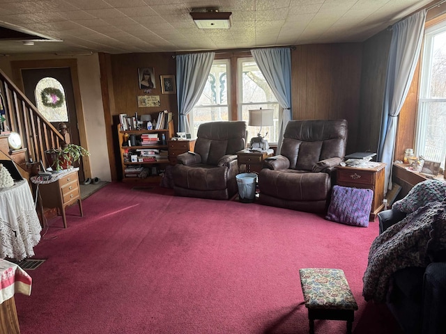 carpeted living room with wooden walls