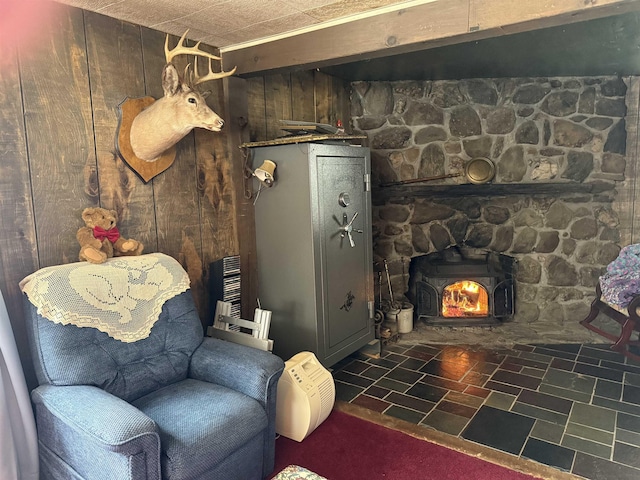 living area featuring a wood stove and wood walls