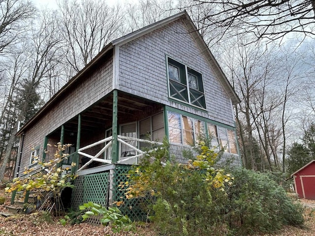 view of side of home featuring a storage shed