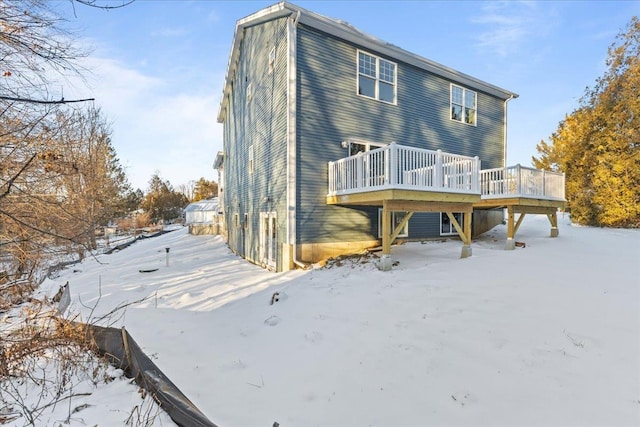 snow covered property with a wooden deck