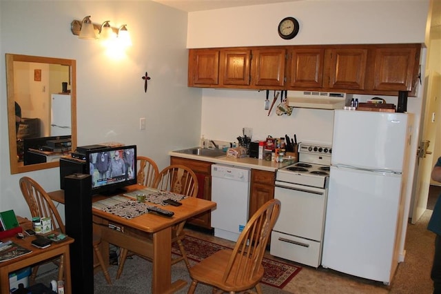 kitchen with sink, white appliances, and range hood