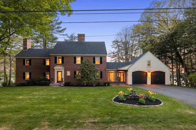 58 Shore Dr, Laconia, NH 03246 - view of front of house with a chimney, an attached garage, asphalt driveway, a front lawn, and brick siding