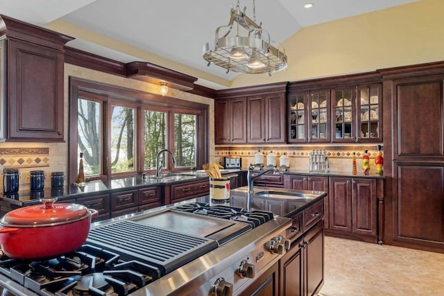 kitchen featuring sink, vaulted ceiling, decorative backsplash, and pendant lighting