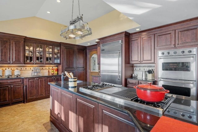 kitchen featuring decorative light fixtures, decorative backsplash, appliances with stainless steel finishes, and vaulted ceiling